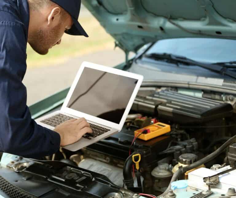 Mechanic using laptop for computerized car scanning and diagnostics – IQ Wheels Hybrids Auto Zone Lahore