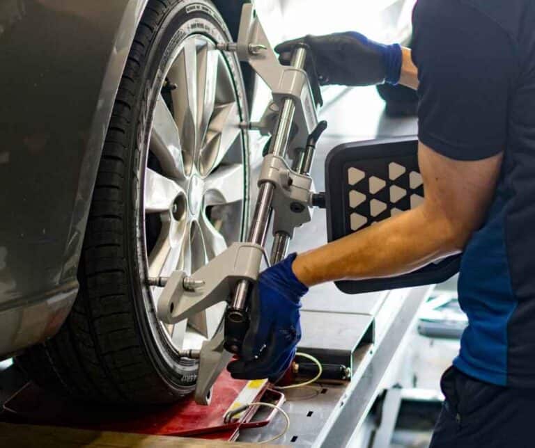 a mechanic aligning car wheel